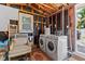 Functional laundry room with exposed wooden beams, washer and dryer, and natural light at 4750 Burlington N Ave, St Petersburg, FL 33713