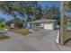 Cozy home with an attached garage, a lush tree providing shade, and a well-maintained lawn at 512 Richmond St, Dunedin, FL 34698