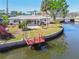 Waterfront backyard with a dock and an enclosed patio and a well manicured lawn near the water at 5167 Venetian Ne Blvd, St Petersburg, FL 33703