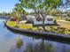 Waterfront property featuring a well-maintained lawn, mature trees and a concrete seawall along the canal at 5167 Venetian Ne Blvd, St Petersburg, FL 33703