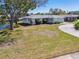 Well-maintained single-story home featuring a manicured lawn and a circular driveway on a canal at 5167 Venetian Ne Blvd, St Petersburg, FL 33703
