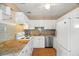 Classic kitchen featuring white cabinetry, granite countertops, stainless steel dishwasher and wood look floors at 5509 18Th S Ave, Gulfport, FL 33707