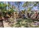 Fenced backyard featuring a wooden swing set with slide, swings, and mature trees at 592 Deer W Run, Palm Harbor, FL 34684