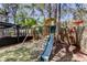 Backyard with wooden swing set, enclosed patio, and mature trees at 592 Deer W Run, Palm Harbor, FL 34684