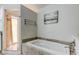 Bathroom featuring a jacuzzi tub with tile surround and separate glass-enclosed shower at 592 Deer W Run, Palm Harbor, FL 34684