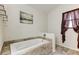 Bright bathroom featuring a tiled tub, a walk-in shower with glass door, a window, and neutral wall art at 592 Deer W Run, Palm Harbor, FL 34684