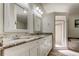 Elegant bathroom featuring double sinks, granite counters, decorative mirrors, soaking tub, and a separate glass shower at 592 Deer W Run, Palm Harbor, FL 34684