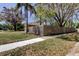 Beautiful home with a large front yard, mature trees, a wooden fence, and a sidewalk at 592 Deer W Run, Palm Harbor, FL 34684