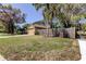 Charming home with a well-maintained front lawn, mature trees, and a wooden fence at 592 Deer W Run, Palm Harbor, FL 34684