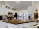 Well-lit kitchen with granite countertops, white cabinets, and stainless steel appliances at 592 Deer W Run, Palm Harbor, FL 34684