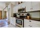 Modern kitchen featuring stainless steel appliances, white cabinetry, and granite countertops at 592 Deer W Run, Palm Harbor, FL 34684