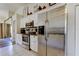 Modern kitchen features stainless steel appliances, white cabinetry, and tile floors at 592 Deer W Run, Palm Harbor, FL 34684