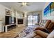 Cozy living room features a fireplace, vinyl floors, and sliding glass doors to a bright backyard at 592 Deer W Run, Palm Harbor, FL 34684