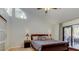 Main bedroom features king bed, high ceiling, and sliding doors to a private outdoor patio at 592 Deer W Run, Palm Harbor, FL 34684