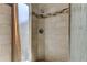 Beautiful tiled shower with a rainfall showerhead and a decorative accent band at 592 Deer W Run, Palm Harbor, FL 34684