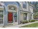 Inviting townhome exterior showcases a red front door and charming architectural details at 6036 Fishhawk Crossing Blvd, Lithia, FL 33547
