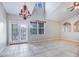 Bright living room boasts high ceilings, tile flooring, and French doors leading to outdoor space at 6036 Fishhawk Crossing Blvd, Lithia, FL 33547