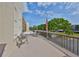 Wide angle view of a condo balcony featuring outdoor seating and a decorative American flag on a beautiful sunny day at 8198 Terrace Garden N Dr # 208, St Petersburg, FL 33709