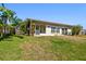 Back exterior of the house with screened in patio and green grass at 8706 Tahiti Ln, Tampa, FL 33615