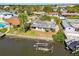 Aerial view of a home with a dock, canal front, and vibrant landscaping in a waterside neighborhood at 8706 Tahiti Ln, Tampa, FL 33615