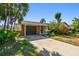 Charming single-story home with a brick facade and a driveway leading to a garage at 8706 Tahiti Ln, Tampa, FL 33615