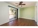 A light-filled bedroom includes a ceiling fan, a sliding glass door, and hardwood flooring at 9037 Pebble Creek Dr, Tampa, FL 33647