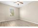 A bright, vacant bedroom features wood floors and a window at 94 S Highland Ave # 2402, Tarpon Springs, FL 34689