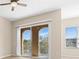 Bedroom with sliding doors to balcony and a window with blinds, neutral walls and wood floors at 94 S Highland Ave # 2402, Tarpon Springs, FL 34689