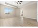 A spacious bedroom features light wood floors, neutral walls, and a large window with neighborhood views at 94 S Highland Ave # 2402, Tarpon Springs, FL 34689