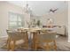 Bright dining room area featuring a chandelier, large windows, and an open floor plan leading to the living room at 94 S Highland Ave # 2402, Tarpon Springs, FL 34689