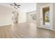 Open-concept living space featuring light hardwood floors, fan and a sliding glass door at 94 S Highland Ave # 2402, Tarpon Springs, FL 34689