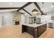 Open-concept living area with a stone fireplace, beamed ceilings, and a spacious kitchen at 0 Old Country Rd, Odessa, FL 33556