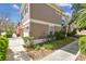 Exterior of a two-story townhome featuring a lush lawn, garden, and a concrete walkway at 11240 Windsor Place Circle Cir, Tampa, FL 33626