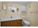 Neutral bathroom features white vanity with wood cabinets, oval mirror, and a toilet at 1270 Gulf Blvd # 506, Clearwater Beach, FL 33767