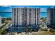 Stunning high-rise condominium exterior view with a pool and lush tropical landscaping at 1270 Gulf Blvd # 506, Clearwater Beach, FL 33767