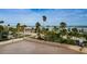 Rooftop view of palm trees, landscaping, and a blue ocean backdrop at 1270 Gulf Blvd # 506, Clearwater Beach, FL 33767