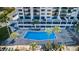 Aerial view of the community pool surrounded by palm trees and lounge seating at 1270 Gulf Blvd # 506, Clearwater Beach, FL 33767