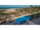 Aerial view of pool surrounded by palm trees, lounge chairs, and beach in the background at 1270 Gulf Blvd # 506, Clearwater Beach, FL 33767