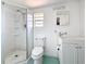 Compact bathroom featuring a glass-enclosed shower, toilet, and vanity with a mirror at 1679 29Th N Ave, St Petersburg, FL 33713