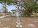 Charming home exterior with a stone pathway leading to the front door, framed by a mature tree at 1679 29Th N Ave, St Petersburg, FL 33713