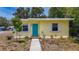 Charming yellow home with a vibrant blue door and a well-maintained front yard at 1679 29Th N Ave, St Petersburg, FL 33713