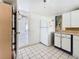 Functional kitchen with white cabinets and tiled floors, ready for updates and personalization at 1679 29Th N Ave, St Petersburg, FL 33713