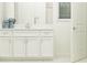 Bright bathroom featuring white cabinets, a large mirror, a modern sink, and a shower with white subway tile at 16969 Falling Waters Ct, Land O Lakes, FL 34638