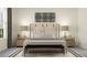 Bedroom with a bed, two side tables, large pillows, and a stylish woven wall hanging at 16969 Falling Waters Ct, Land O Lakes, FL 34638