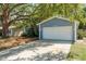 Two-car garage, lush, landscaped yard with mature trees. An elegant home with curb appeal at 1721 Sutton Pl, Dunedin, FL 34698