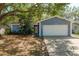 Charming home featuring a lush, landscaped yard with mature trees and a two-car garage at 1721 Sutton Pl, Dunedin, FL 34698