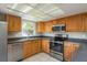 Bright kitchen features stainless steel appliances, tile floors and dark countertops at 1721 Sutton Pl, Dunedin, FL 34698