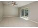 Open living room with tile flooring, ceiling fan, and sliding glass doors to patio at 1721 Sutton Pl, Dunedin, FL 34698