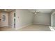 Spacious, neutral living room and entry with tile flooring, ceiling fan and sliding glass doors at 1721 Sutton Pl, Dunedin, FL 34698