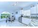 A kitchen showcasing granite countertops, white cabinets, and a bright breakfast nook featuring a large arched window at 1915 Fellsway Ct, Wesley Chapel, FL 33543